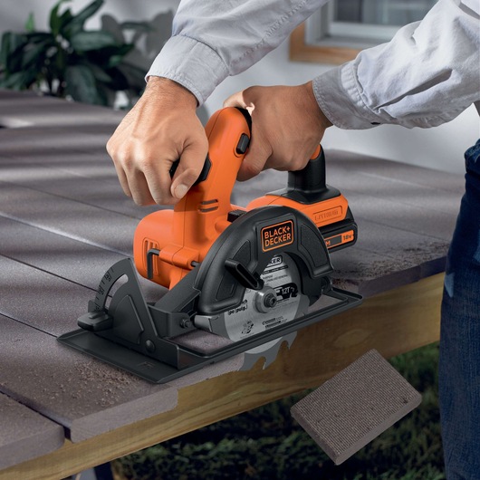 BLACK+DECKER BDCCS18N cordless circular saw cutting wood, close-up action view.