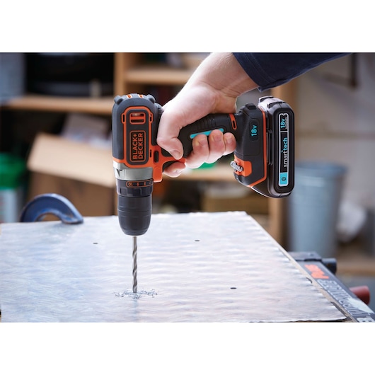 Photo of BLACKDECKER BDCDC18KST cordless drill with smarttech battery drilling into metal sheet.
