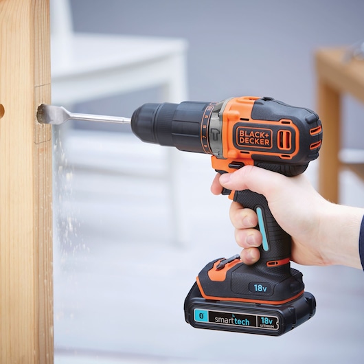 Photo of BLACK+DECKER BDCHD18KBST cordless drill with 18V battery drilling into wood.