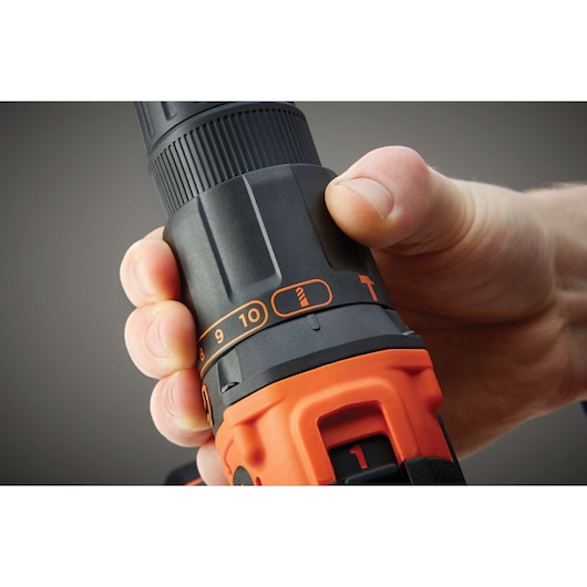 Close-up photo of hand adjusting torque setting on BLACKDECKER BDCHD18 cordless drill, showing control dial.