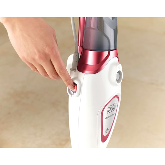 BLACKDECKER BDS1616R steam mop close-up with hand pressing red power button.