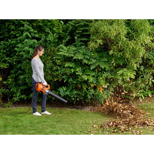 BLACKDECKER BEBL185 corded leaf blower used outdoors to clear leaves on grass.