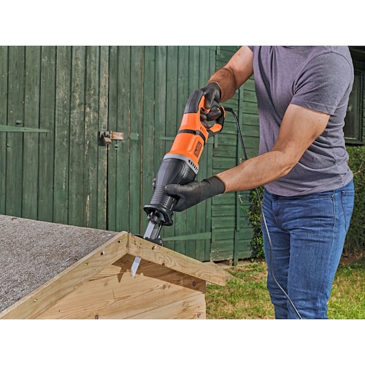 BLACKDECKER BES301 reciprocating saw in use cutting wood outdoors.