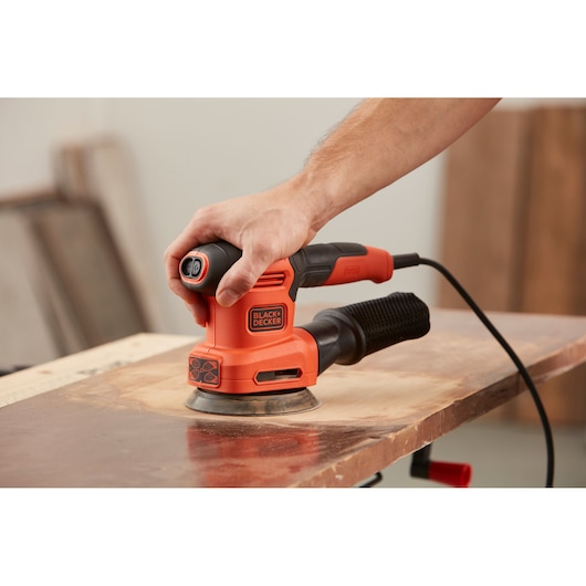 BLACKDECKER BEW200 electric sander in use on wood surface, shown in close-up photography.
