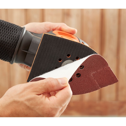 BLACKDECKER BEW200 detail sander with sanding sheet being attached, close-up photo.