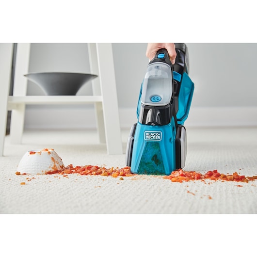 BLACKDECKER BHSB320JP handheld carpet cleaner removing food spill on cream carpet, front angle.