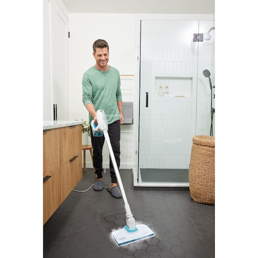 BLACK+DECKER BHSM15FX08 steam mop cleaning black hexagon tile bathroom floor by shower.