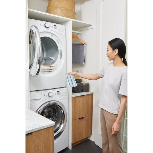 BLACKDECKER BHSM15FX08 microfiber mop pad held in hand in laundry room with washer and dryer.