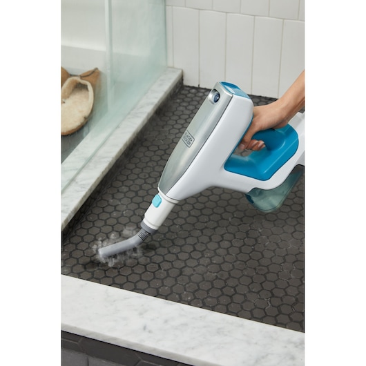 BLACKDECKER BHSM15FX08 steam cleaner being used on black hex tile near shower.