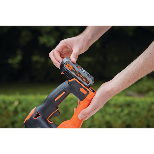 BLACKDECKER GTC18502PC cordless tool with 18V lithium battery being inserted, outdoor background.