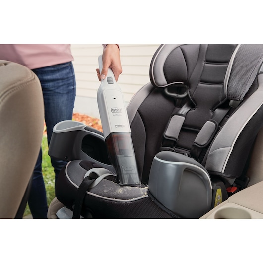 BLACKDECKER HLVC315J11 handheld vacuum cleaning crumbs from a child car seat.