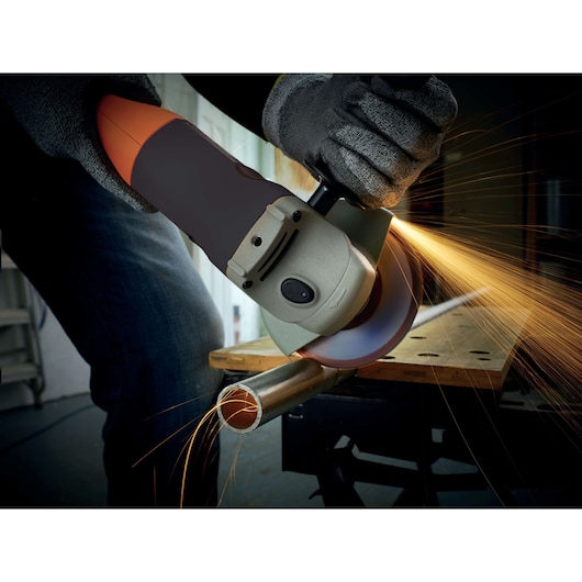 BLACKDECKER KG1202 angle grinder cutting metal pipe, sparks flying, close-up action shot.