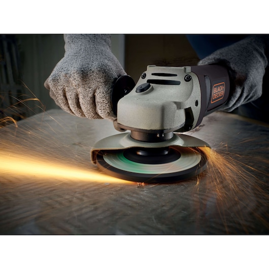 BLACKDECKER KG1202 angle grinder in use cutting metal, close-up with sparks flying.