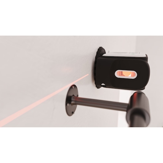 BLACKDECKER REVBDLL100 laser level mounted on wall projecting red line across white surface.