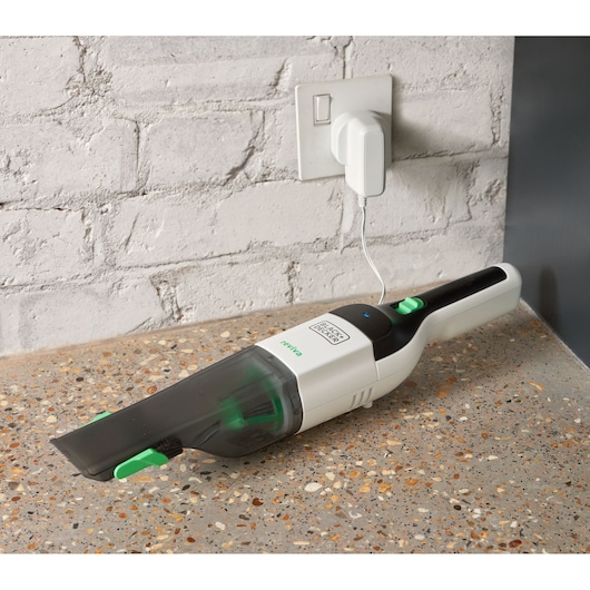 BLACKDECKER REVHV8C handheld vacuum being charged on a speckled countertop, angled side view.