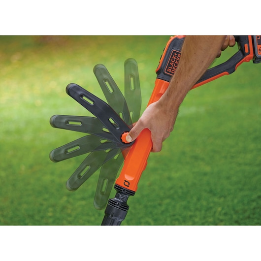 Photo of BLACK+DECKER STC1820PC grass trimmer showing adjustable head in multiple positions.