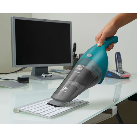 BLACKDECKER WDB115WA handheld vacuum cleaning keyboard on desk in office setting