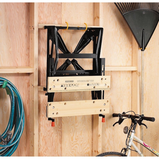 BLACK+DECKER WM536 folding workbench with bamboo top mounted on a wooden garage wall, photography, front angle.