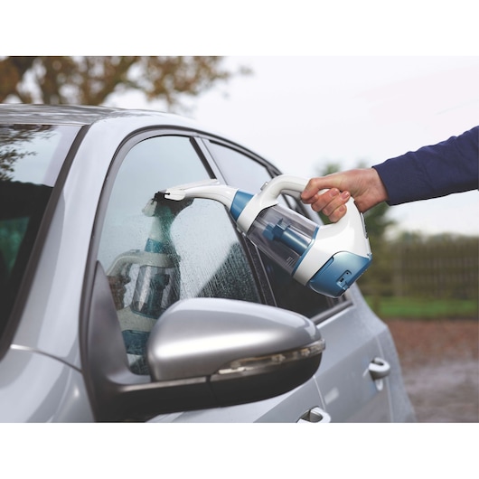 BLACKDECKER WW100 window vacuum cleaner used on a car side window, showing handheld design and blue accents.