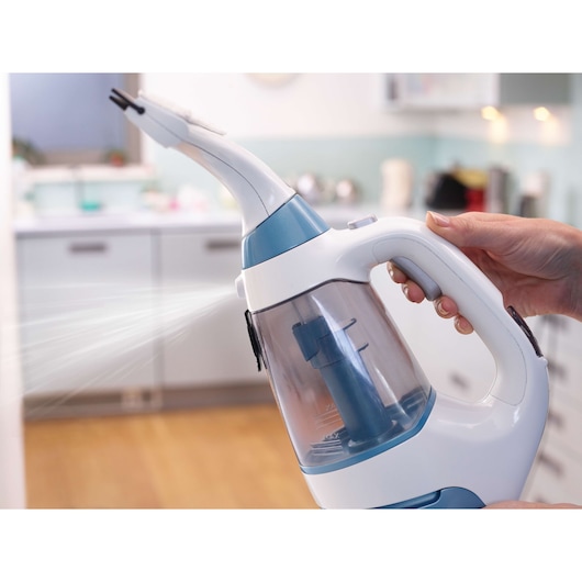 BLACKDECKER WW100 handheld steam cleaner in use, spraying in a kitchen setting.